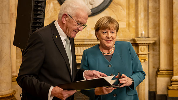 Angela Merkel von Winfried Kretschmann ausgezeichnet – „Geschafft, Schaden vom Volk abzuwenden“